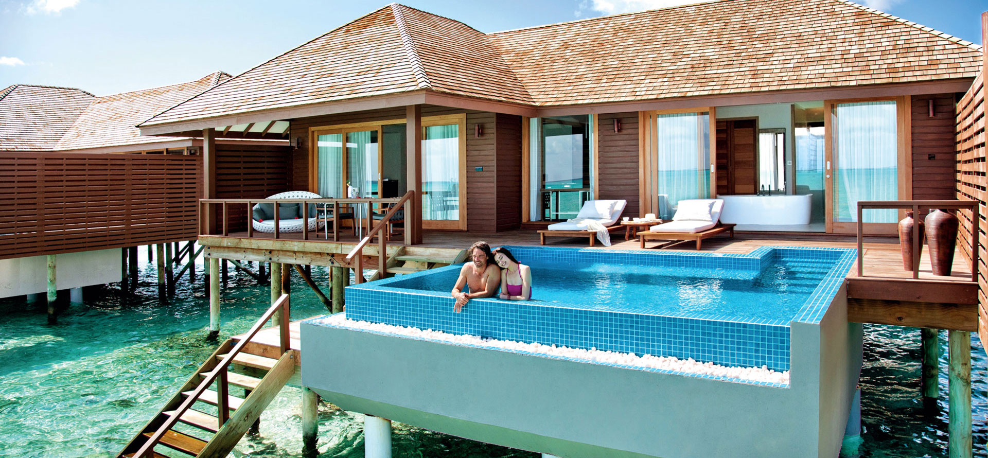 Couple in swimming pool in Maldives overwater bungalow.