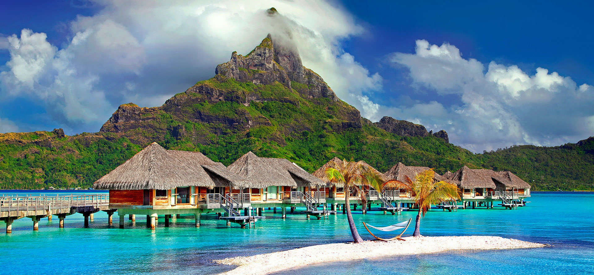 Bora Bora owerwater villas with view at mountains.